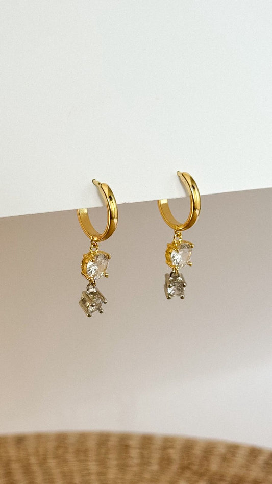 Par de argolas douradas com pedras